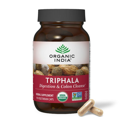 Organic triphala capsules in glass jar for digestion and colon cleansing.