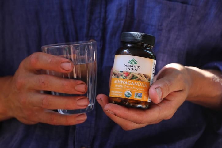 Ashwagandha side effects man holding capsules and water