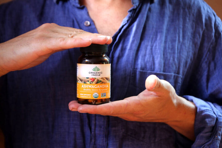 a man holding organic india capsule in his hand