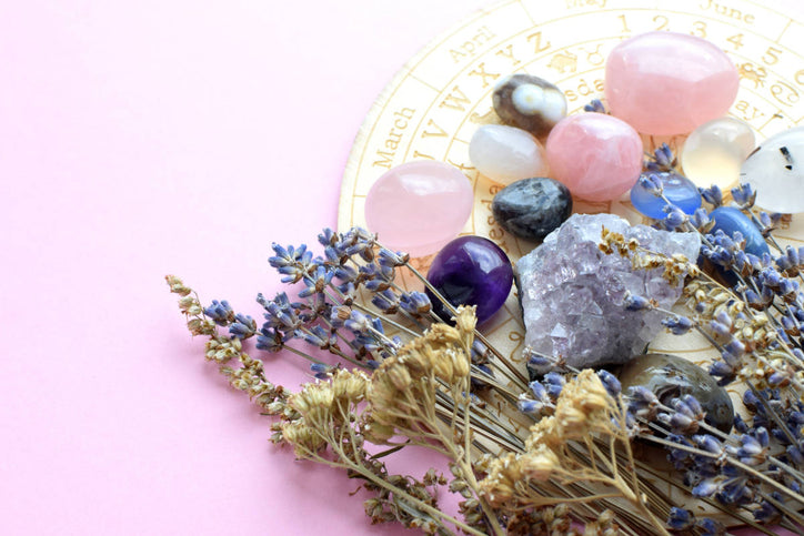 stones and herbs placed against a light pink background