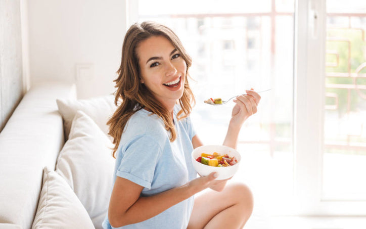 woman eating fruit from a bowl