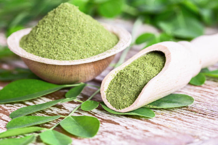 moringa powder in a wooden spoon and bowl