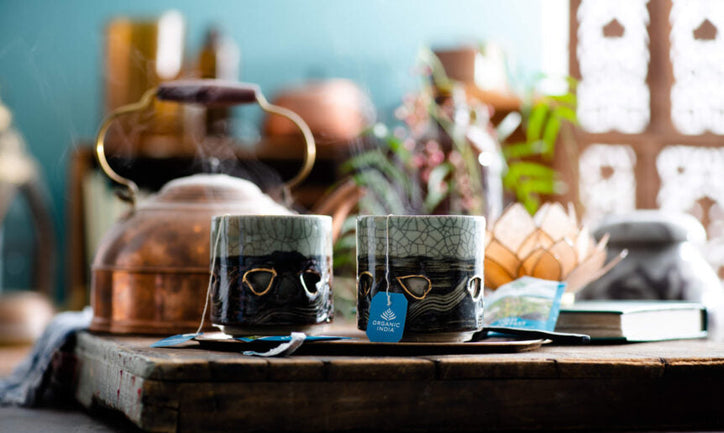 2 mugs on a table with organic india tulsi teabags