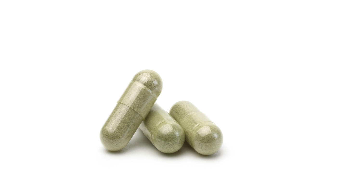 Three green capsules on a white background